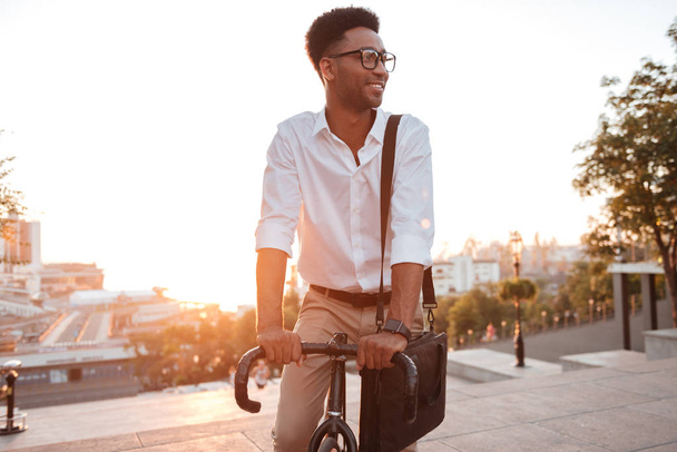 Concentrated young african man early morning with bicycle - Foto, Bild