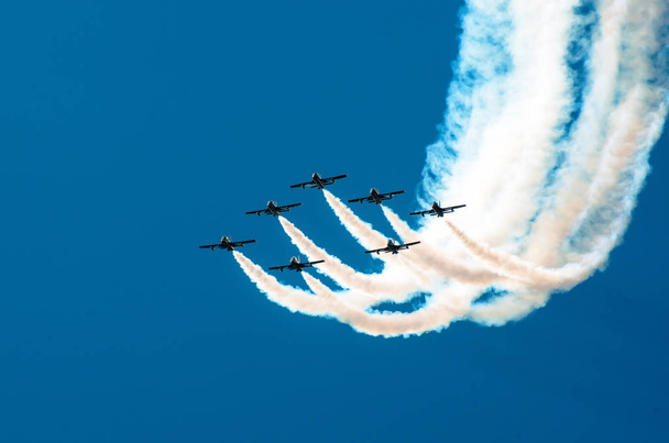 Боєць літає в диму в синьому небі пілотажної пілотажної
 - Фото, зображення