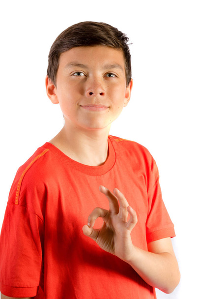 Young teenage boy isolated on white giving "OK" sign - Photo, Image