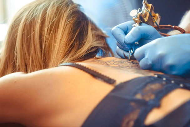 master tattoo woman on her back - Photo, Image