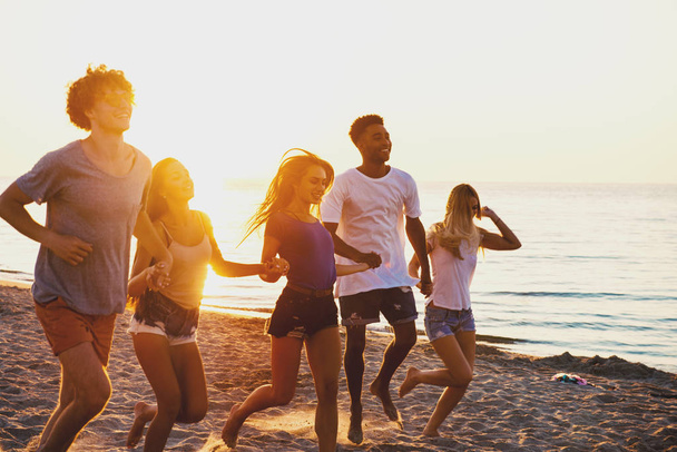 Grupo de amigos felizes se divertindo na praia do oceano
 - Foto, Imagem