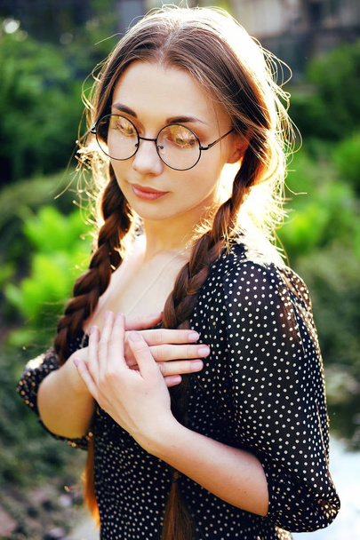 Retrato de mujer joven en gafas mirando medallón de plata regalo
 - Foto, imagen