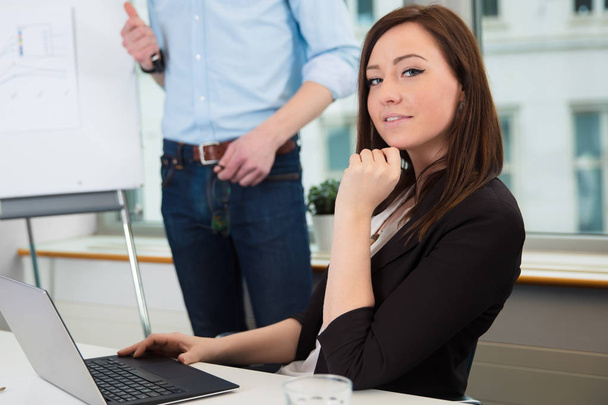 Businesswoman Using Laptop While Colleague Giving Presentation - Photo, Image