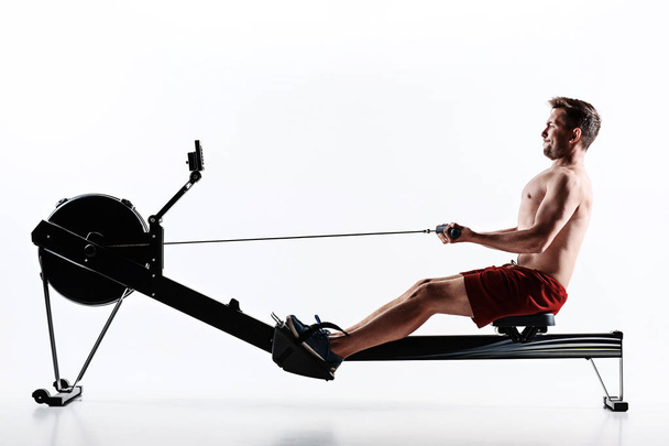 Man Using A Press Machine In A Fitness Club. - Fotó, kép