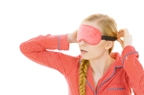 Sleepy woman wearing pink eye band - Фото, изображение