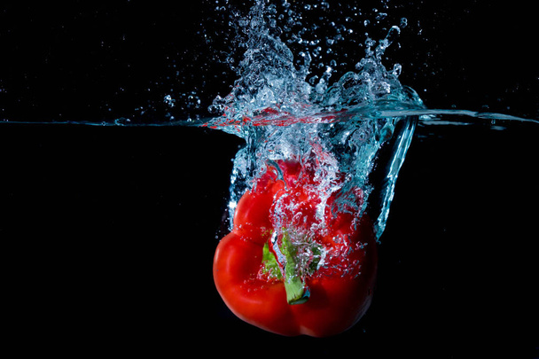 Rode Bell paprika wegviel in Water - Foto, afbeelding