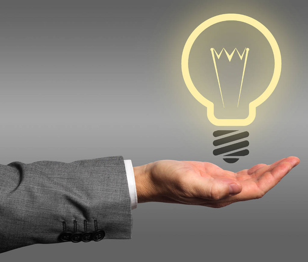 Businessman with illuminated idea bulb in hand - Foto, Imagen