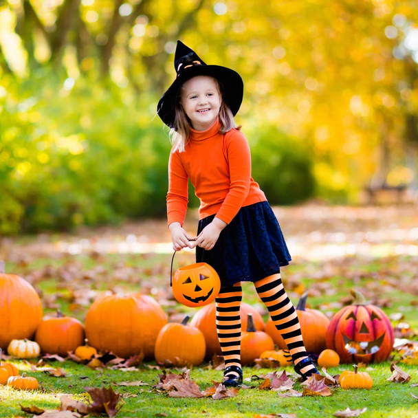 Klein meisje in heks kostuum op Halloween truc of traktatie - Foto, afbeelding