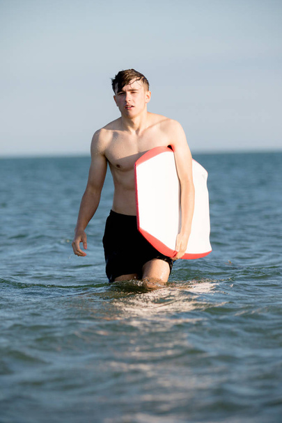 Teenage boy with a body board in the sea - Φωτογραφία, εικόνα
