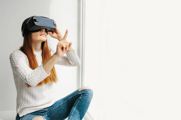 Mujer joven con gafas de realidad virtual. Concepto de tecnología futura. Tecnología de imagen moderna
. - Foto, Imagen