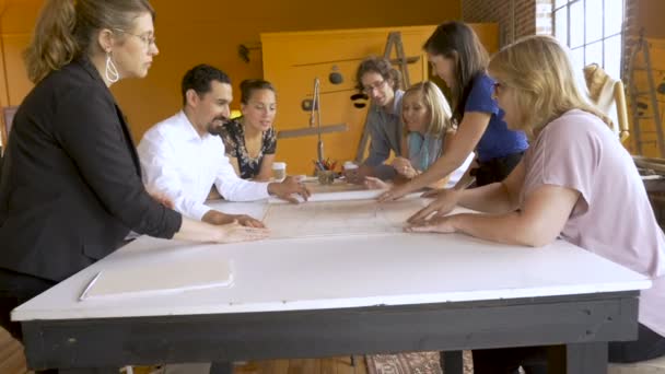 Female manager reveals blueprints to her fellow startup coworkers in slow motion - Footage, Video