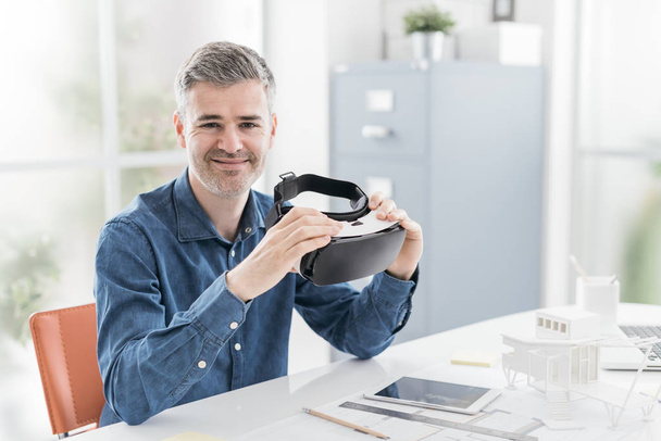 Architect holding a VR headset - Фото, изображение