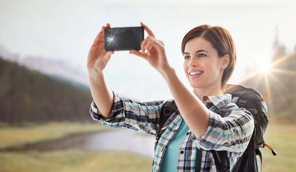 Hiker taking pictures with a smartphone - Foto, Imagem