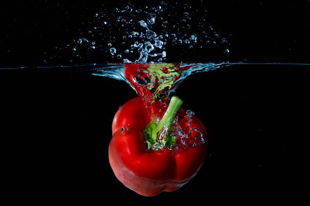 Red Bell Sweet Pepper Droped Into Water - Foto, afbeelding