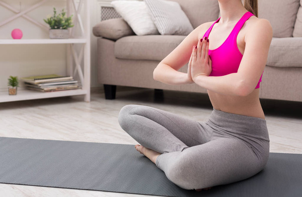 Woman training yoga in lotus pose, closeup - 写真・画像