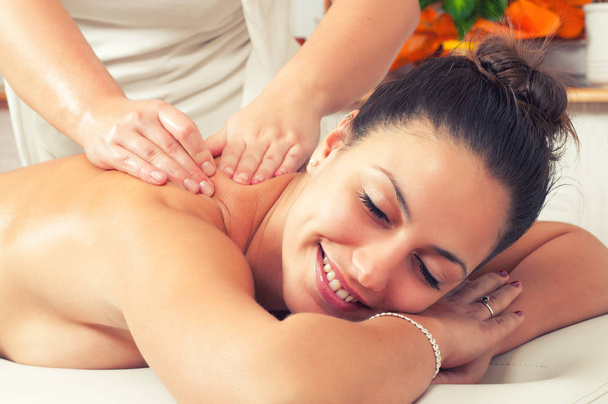 Mulher feliz desfrutando de massagem nas costas profissional no salão de beleza moderna
 - Foto, Imagem