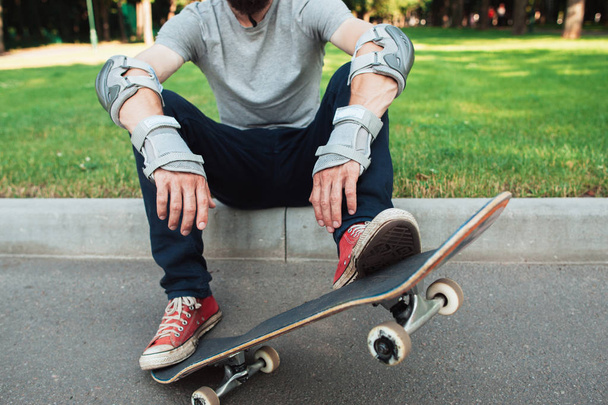 Unrecognizable skateboarder has a short break - Foto, afbeelding