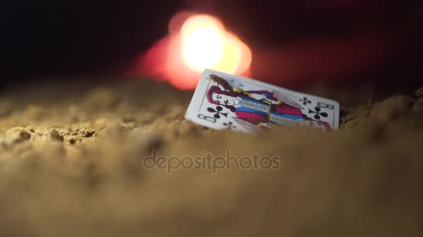 Παιχνίδια κάρτα Jack στην άμμο. Μήκος σε πόδηα. Σκαθάρι σέρνεται στην κάρτα είναι Jack, φωτιά στο παρασκήνιο. Αφηρημένη παιγνιόχαρτο επιτόπου. Παλιά παιγνιόχαρτο Jack - Πλάνα, βίντεο