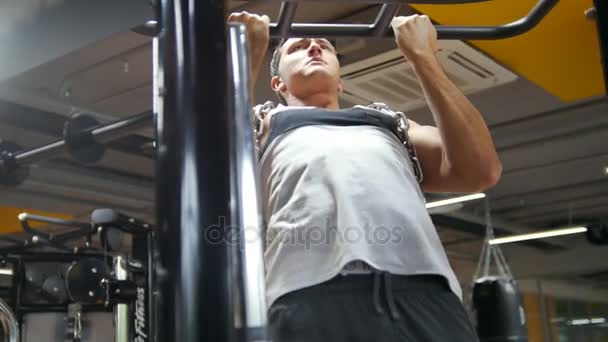 Bodybuilder in the gym performs pull up for biceps with metal chain - Imágenes, Vídeo