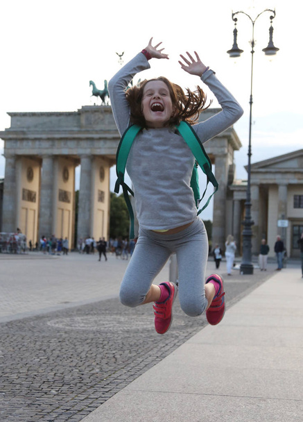 little girl makes a big jump in front of the Brandenburg Gate - Fotoğraf, Görsel