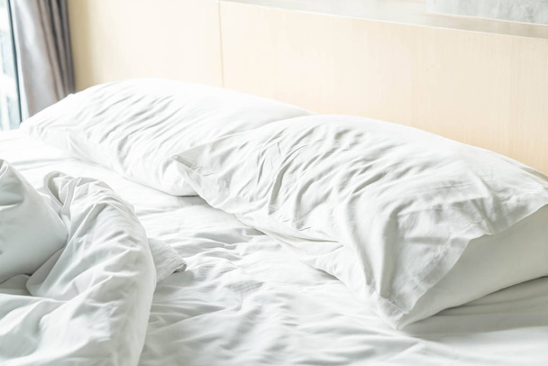 rumpled bed with white messy pillow  - Zdjęcie, obraz