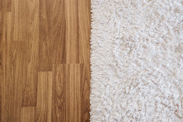 Közelkép luxus fehér szőnyeg a Laminált fa padló a nappaliban, belső dekoráció - Fotó, kép