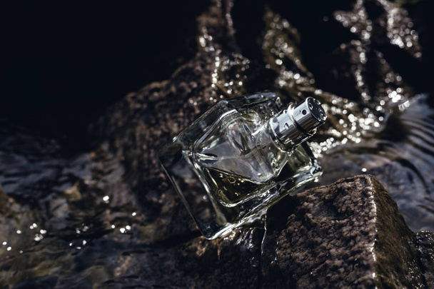Perfume bottle located on the rocks - Foto, afbeelding