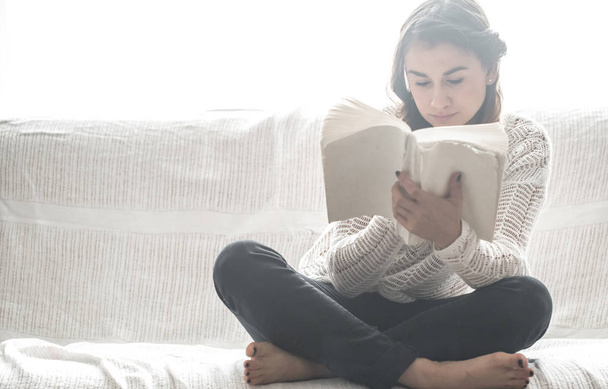 дівчина читає книгу на дивані
 - Фото, зображення