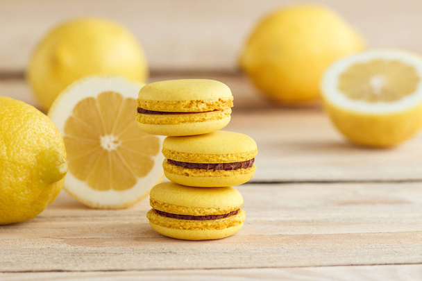 Yellow french macarons with lemons on the wooden board - Photo, Image