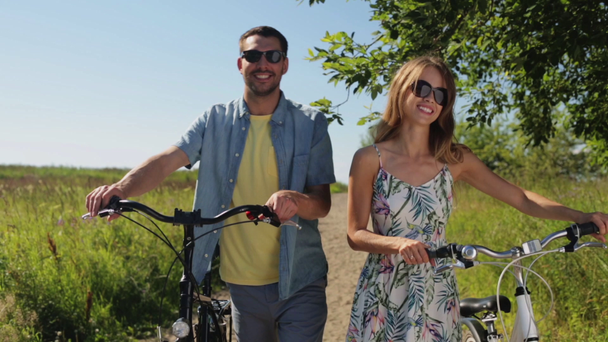 Szczęśliwa Młoda para z rowerami, pieszo latem - Materiał filmowy, wideo