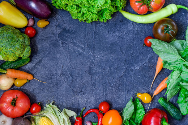 Rahmen von Bio-Lebensmitteln. frisches rohes Gemüse und Grünzeug auf dem dunklen Betongrund. gesunder Lebensstil. Entgiftung, Diät. Raum für Text, selektiver Fokus - Foto, Bild