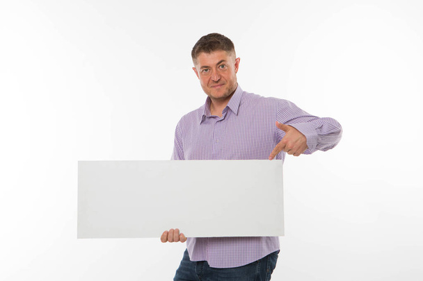 Young confident man showing presentation, pointing on placard. - Foto, imagen