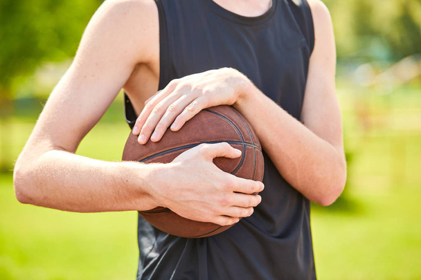 Ruce držící basketbalový míč  - Fotografie, Obrázek