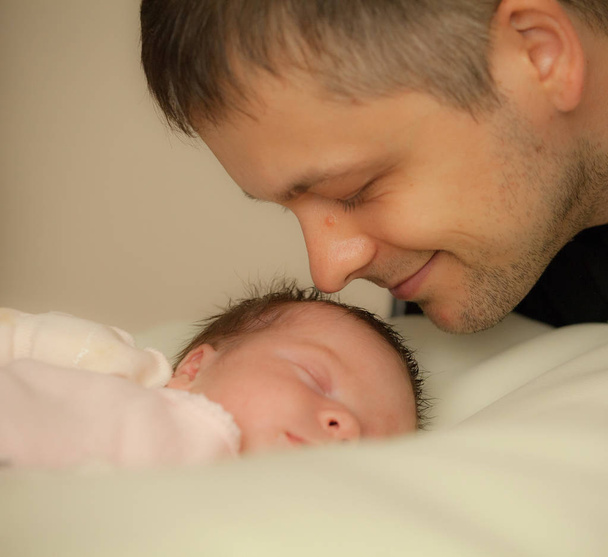 Happy family. Dad Looks with love on his newborn daughter. - Valokuva, kuva