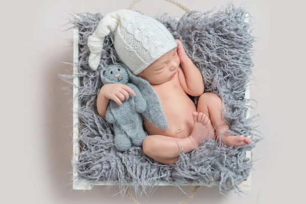 sleeping newborn boy with a hare - Фото, зображення