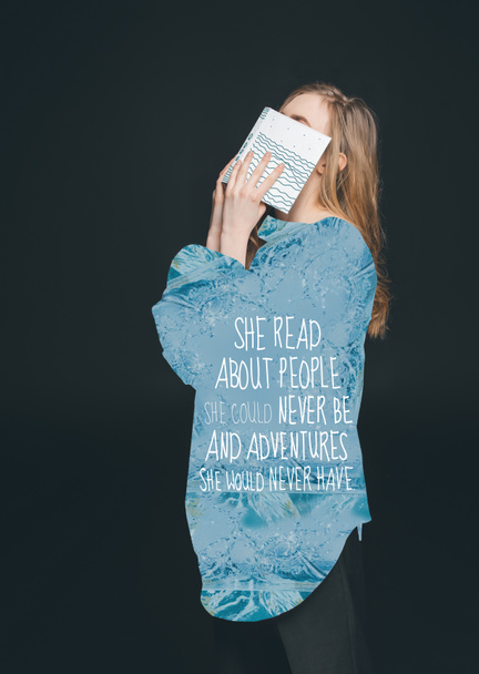 дівчина ховається обличчям за книгою
 - Фото, зображення