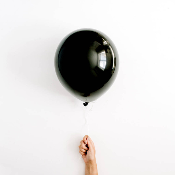 Один чёрный шарик в руке девушки
 - Фото, изображение