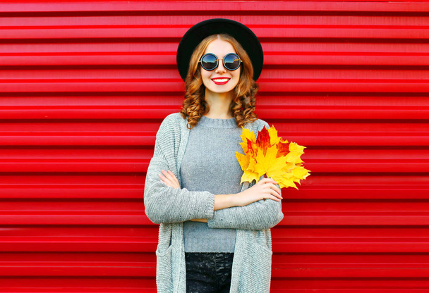 Fashion autumn portrait smiling woman holds yellow maple leaves  - Foto, afbeelding