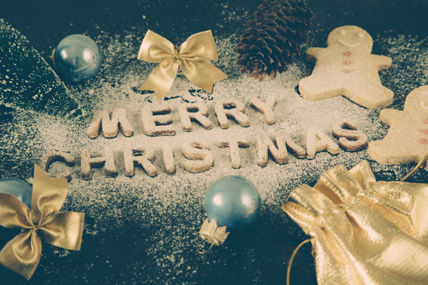 ジンジャーブレッドのクッキーとカード。焼き文字メリー クリスマス - 写真・画像