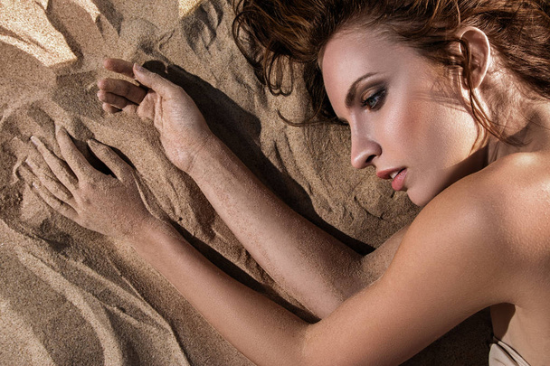 Woman lying on the sand - Valokuva, kuva
