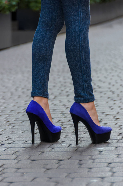 Belles jambes féminines minces en jeans serrés et chaussures bleues sur un
 - Photo, image