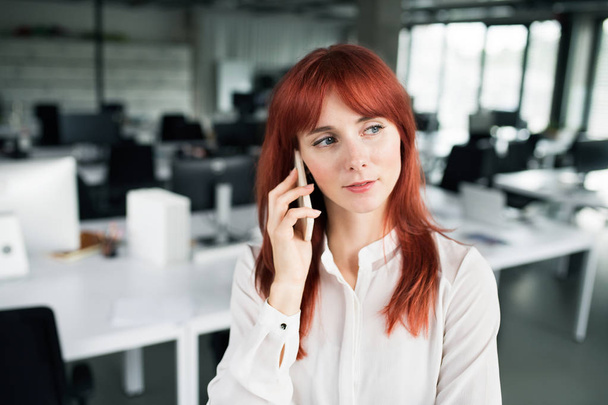Businesswoman with smartphone in her office working. - Foto, Imagen