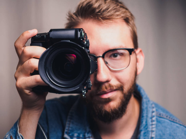 Photographe masculin avec appareil photo dans le bras
 - Photo, image