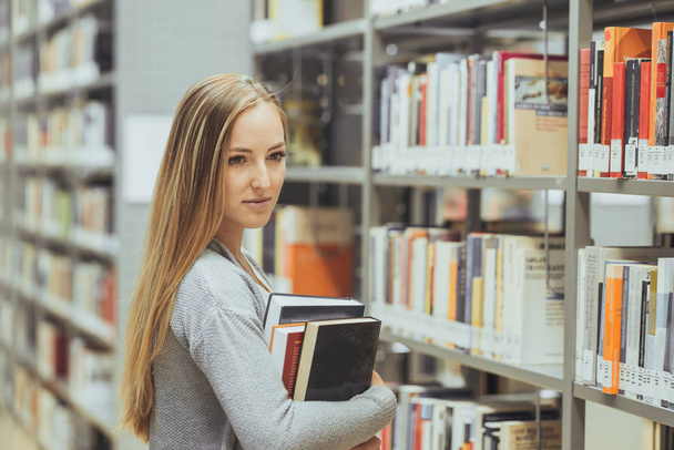 pretty female student learning in a high school library  - Fotografie, Obrázek