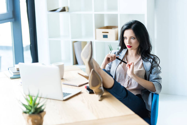 Femme d'affaires sur le lieu de travail avec ordinateur portable
 - Photo, image