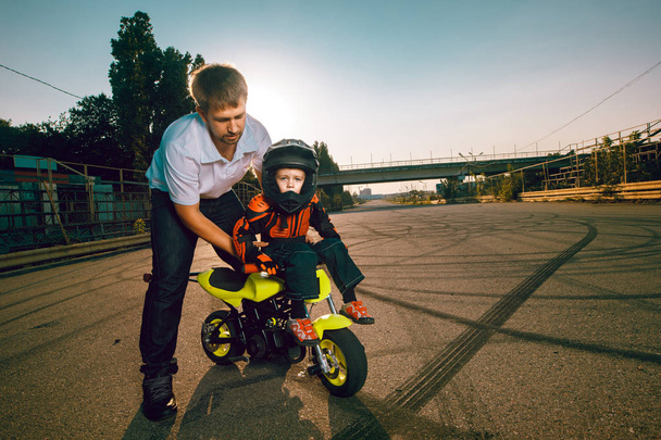 Entraîneur enseigne aux petits motards à faire des cascades sur une moto
 - Photo, image
