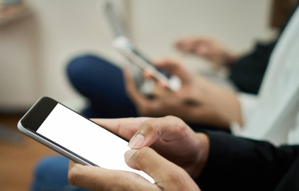 człowiek gospodarstwa smartphone siedzieć biały ekran z przyjaciółmi, z kolegami - Zdjęcie, obraz