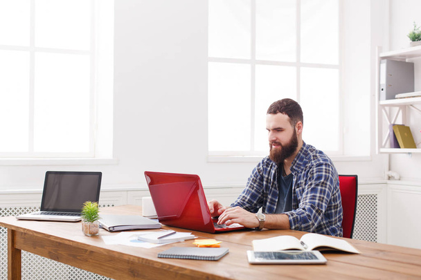 Jonge zakenman die werken met de laptop in moderne witte kantoor - Foto, afbeelding
