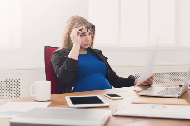 Fiatal terhes nő használ smartphone irodában - Fotó, kép