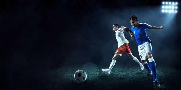 Jalkapallon pelaajat suorittavat toiminta pelata ammattilaisstadionilla
 - Valokuva, kuva
